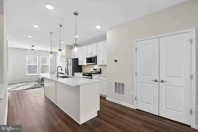 a kitchen with a sink stove and wooden floor
