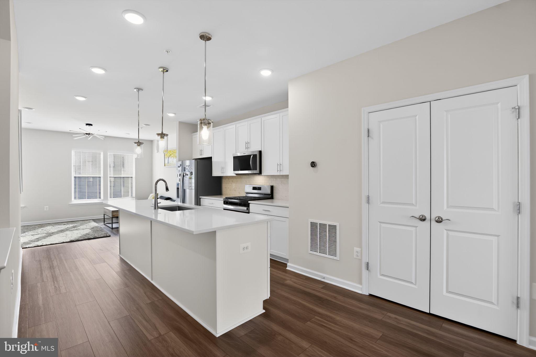 299 Freshet Lane Laurel, MD 20724 - Photo 21 of 33 a kitchen with stainless steel appliances kitchen island granite countertop a refrigerator a stove a sink and white cabinets with wooden floor