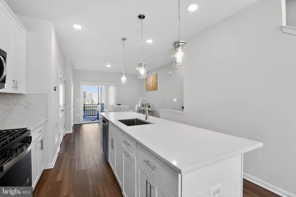 a kitchen with stainless steel appliances granite countertop white cabinets a stove a sink and a refrigerator