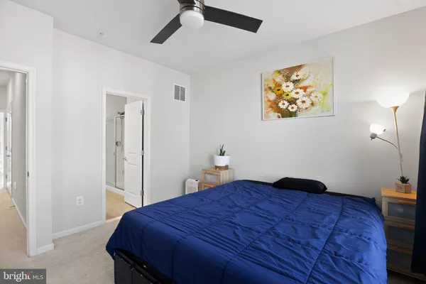 a bedroom with a bed and a painting on the wall