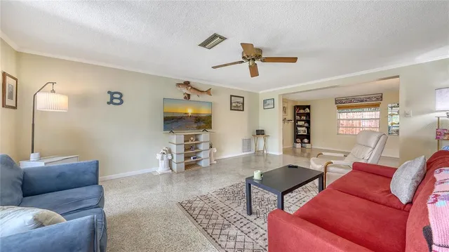 a living room with furniture a flat screen tv and a window