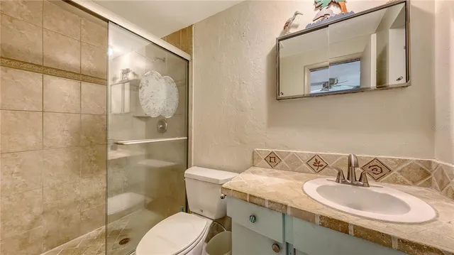 a bathroom with a granite countertop toilet sink and mirror
