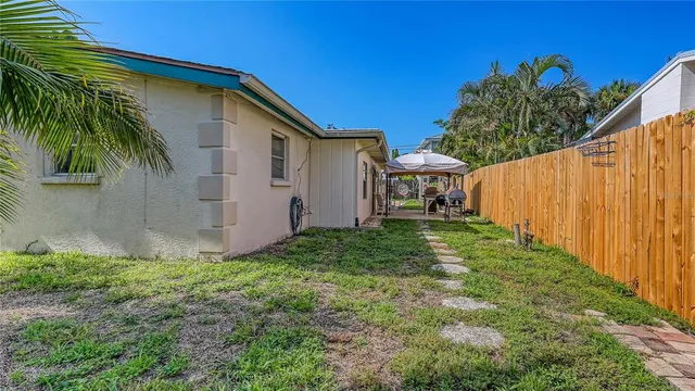 a view of backyard with potted plants and wooden fence