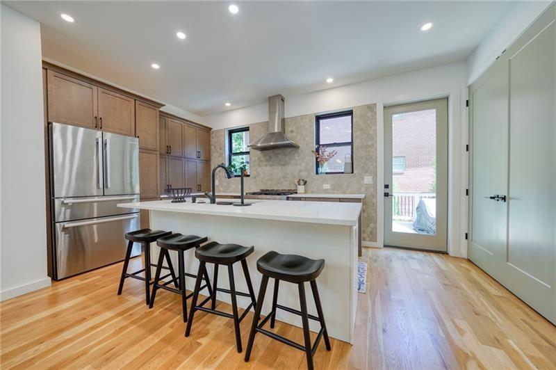 829 Barnett Street Northeast Atlanta, GA 30306 - Photo 11 of 41 a kitchen with stainless steel appliances a refrigerator a sink dishwasher and a stove with wooden floor