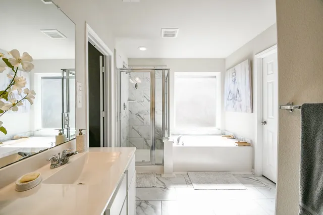 a spacious bathroom with a tub shower and a sink