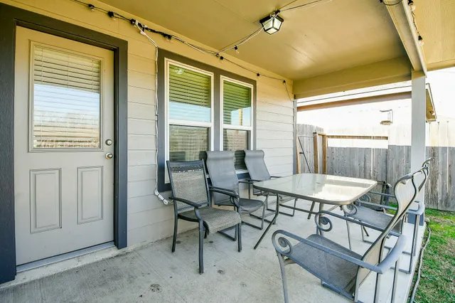 a view of a patio with table and chairs and potted plants