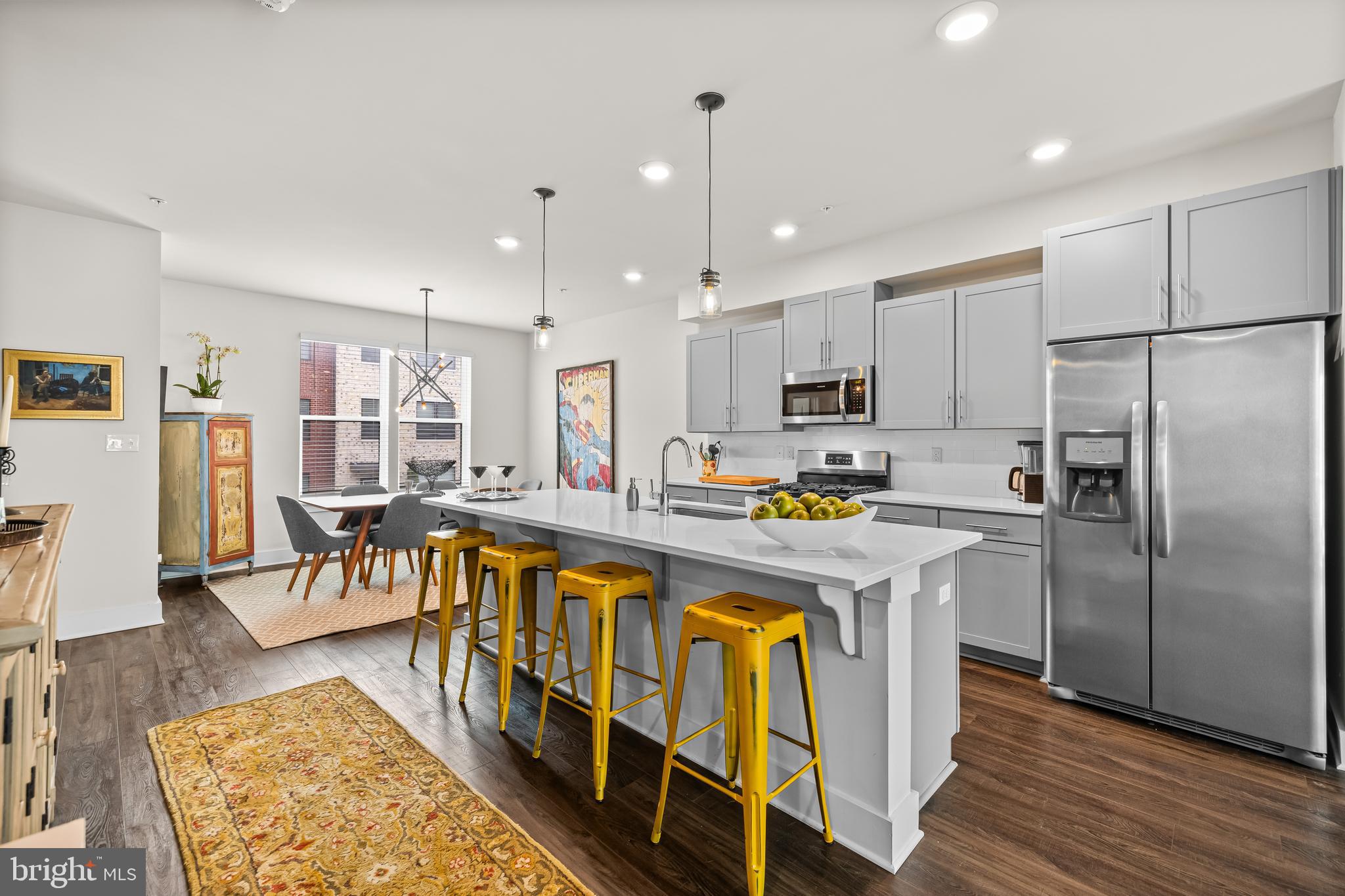 a kitchen with stainless steel appliances granite countertop a refrigerator a stove top oven and a center island