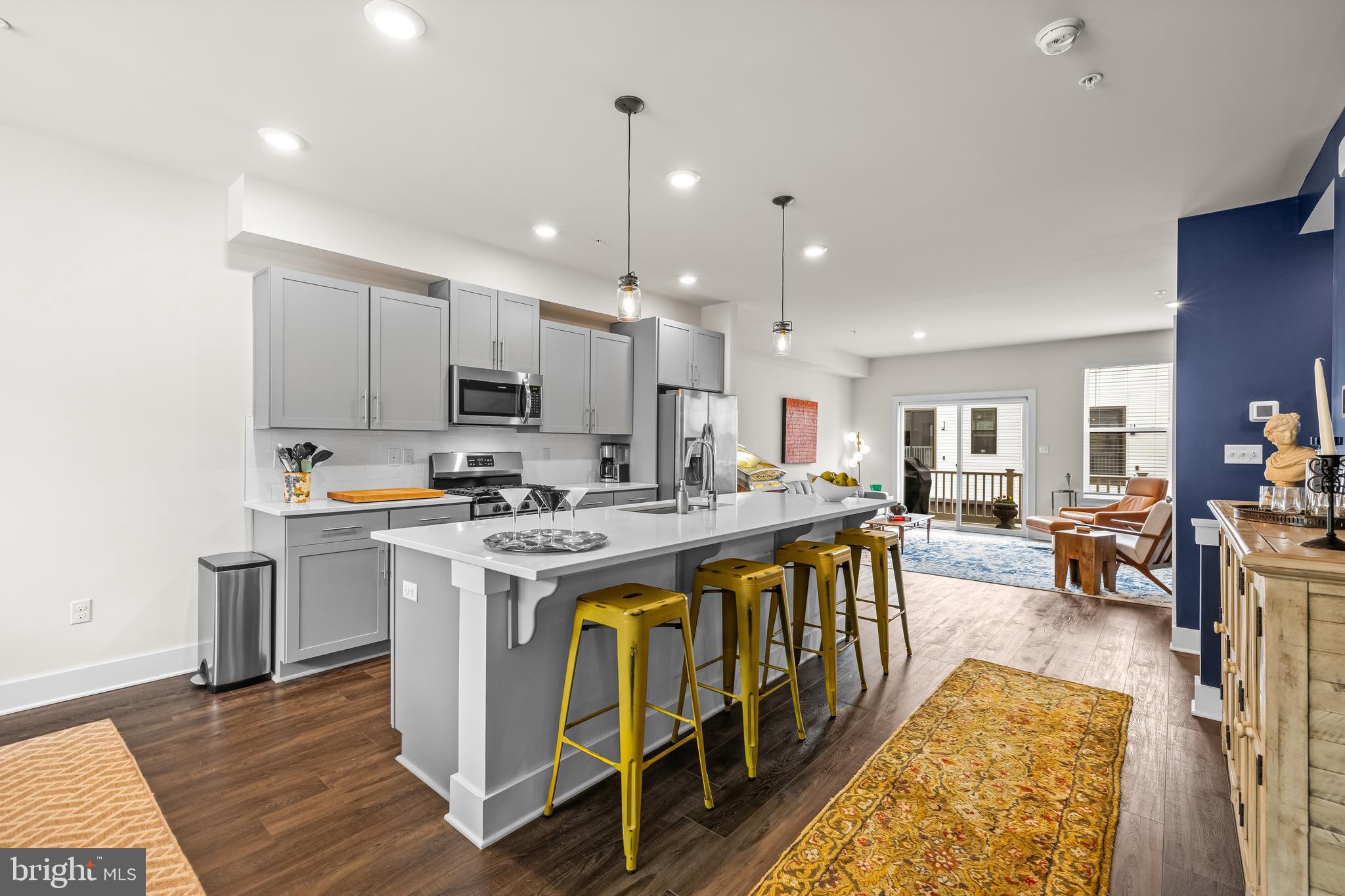 4307 La Plata Avenue Baltimore, MD 21211 - Photo 20 of 54 a large kitchen with kitchen island a stove a sink a refrigerator and a dining table with wooden floor
