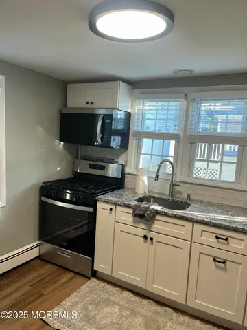 a kitchen with granite countertop a sink stainless steel appliances and cabinets