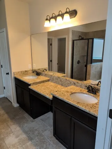 a bathroom with a granite countertop sink and a mirror