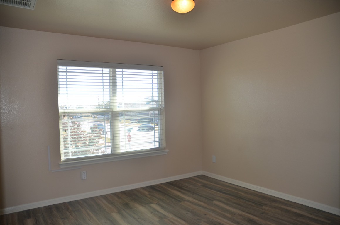 8528 Reggio Street Round Rock, TX 78665 - Photo 20 of 27 an empty room with wooden floor and windows