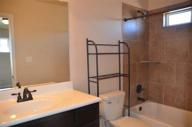 a bathroom with a sink toilet vanity and shower