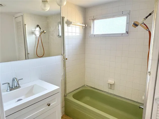 a bathroom with a tub a sink and a shower