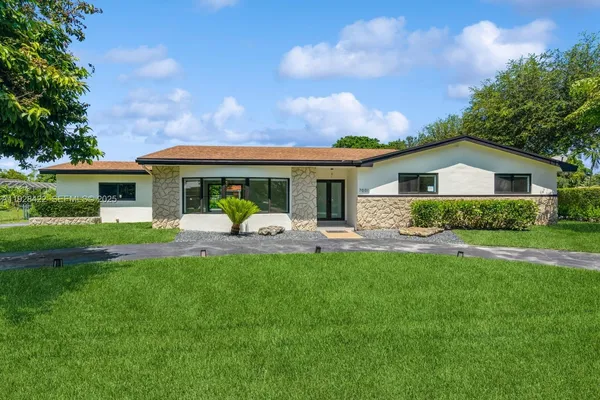 a front view of house with yard and green space