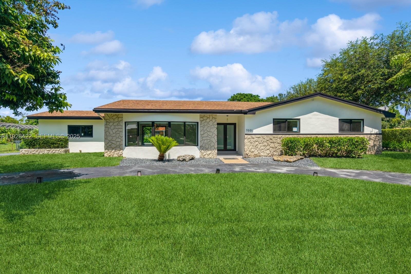 7001 Southwest 126th Street Pinecrest, FL 33156 - Photo 1 of 35 a front view of house with yard and green space
