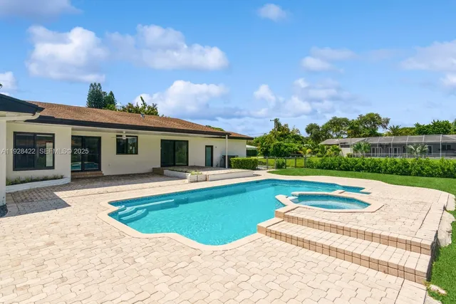 a view of a house with a swimming pool and a yard