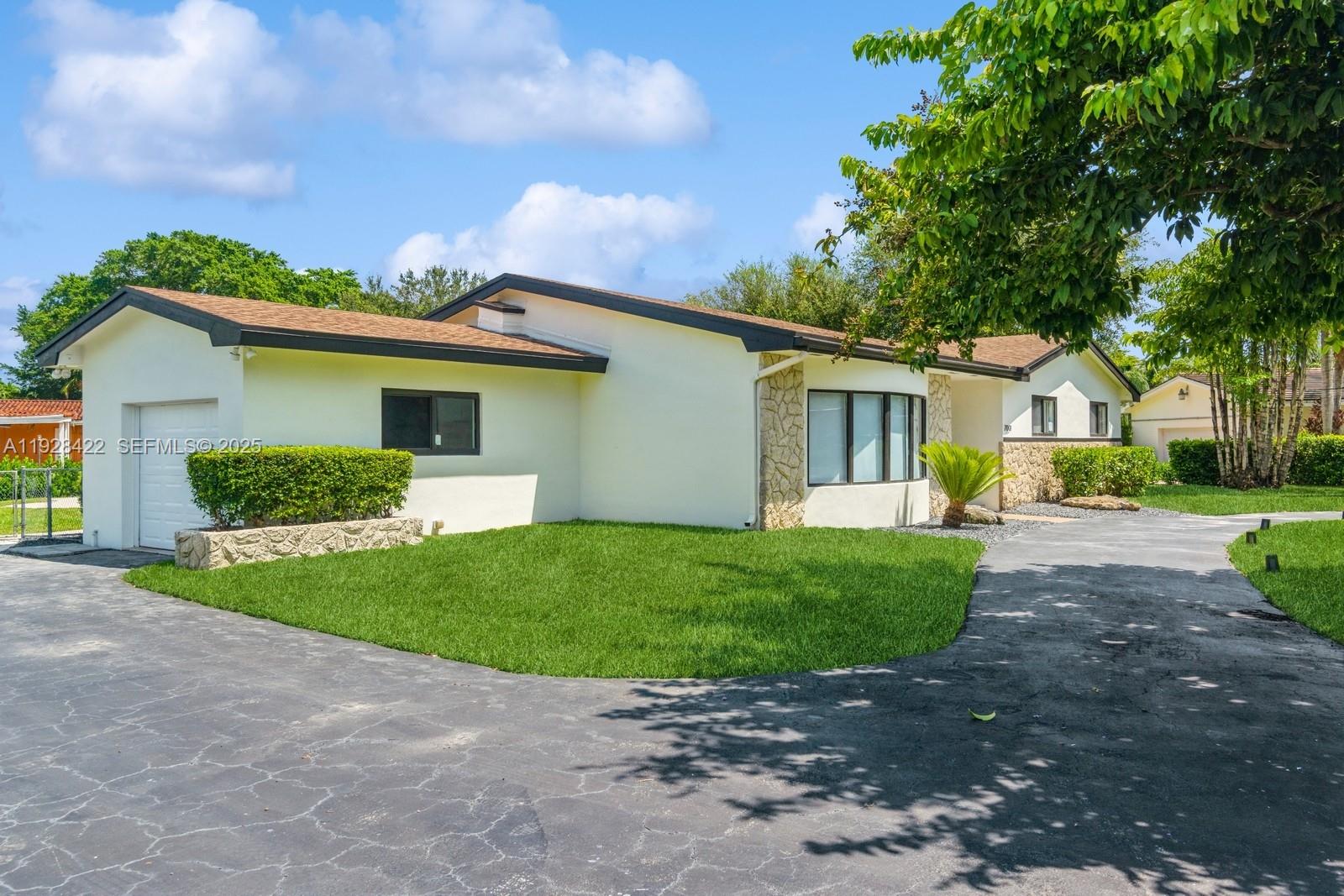 7001 Southwest 126th Street Pinecrest, FL 33156 - Photo 28 of 35 a front view of a house with a yard and garage