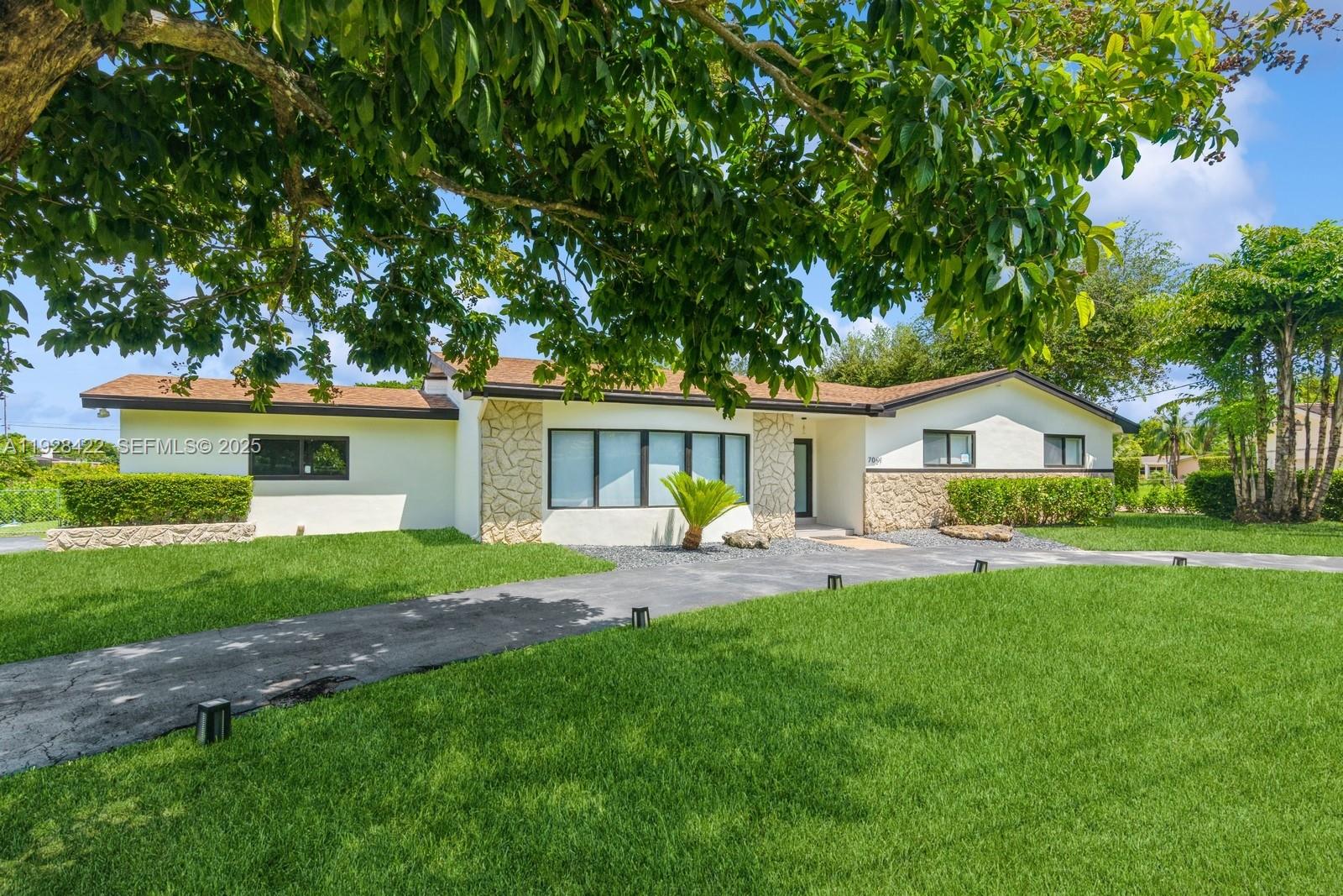 7001 Southwest 126th Street Pinecrest, FL 33156 - Photo 3 of 35 a front view of house with a garden and patio