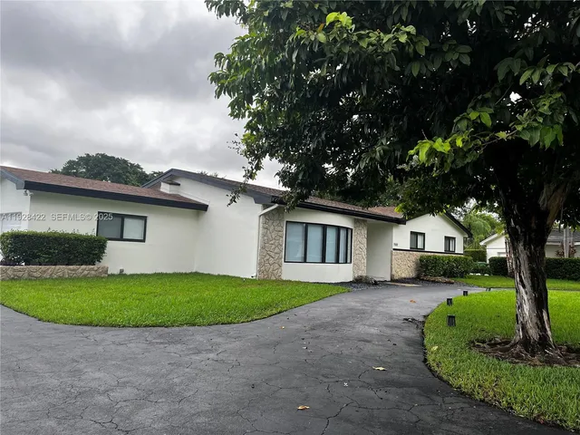 a front view of a house with a garden and yard