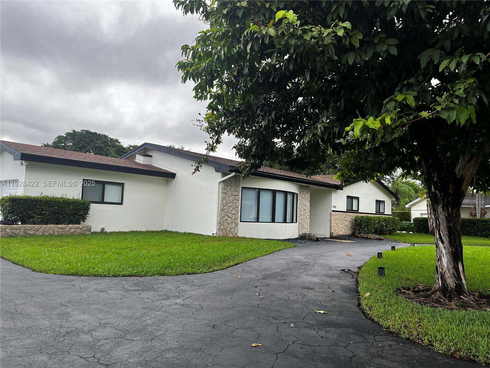 7001 Southwest 126th Street Pinecrest, FL 33156 - Photo 34 of 35 a front view of a house with a garden and yard