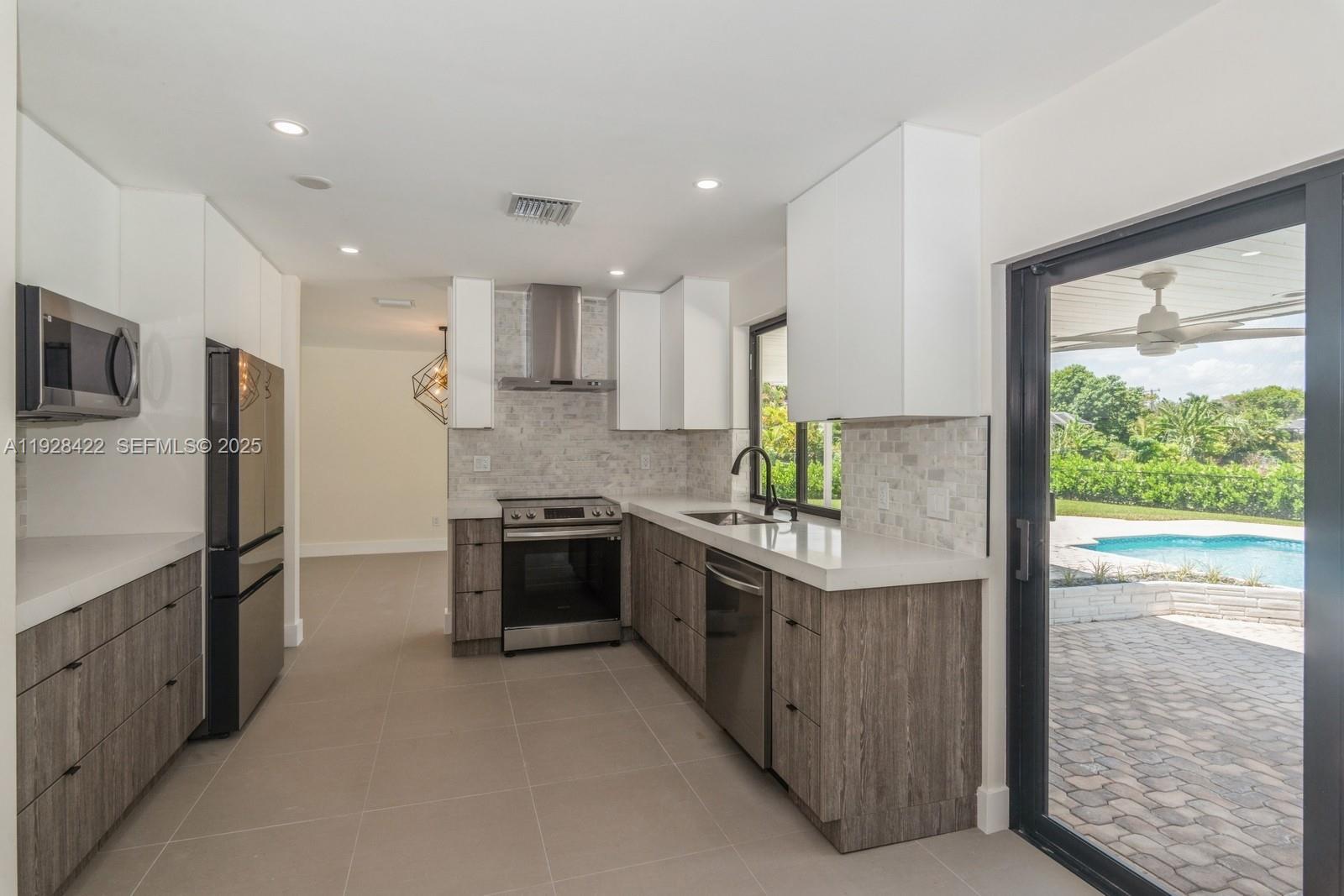 7001 Southwest 126th Street Pinecrest, FL 33156 - Photo 7 of 35 a kitchen with stainless steel appliances granite countertop a stove and a refrigerator
