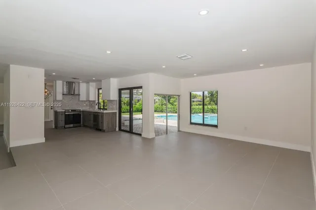 an empty room with furniture and a kitchen