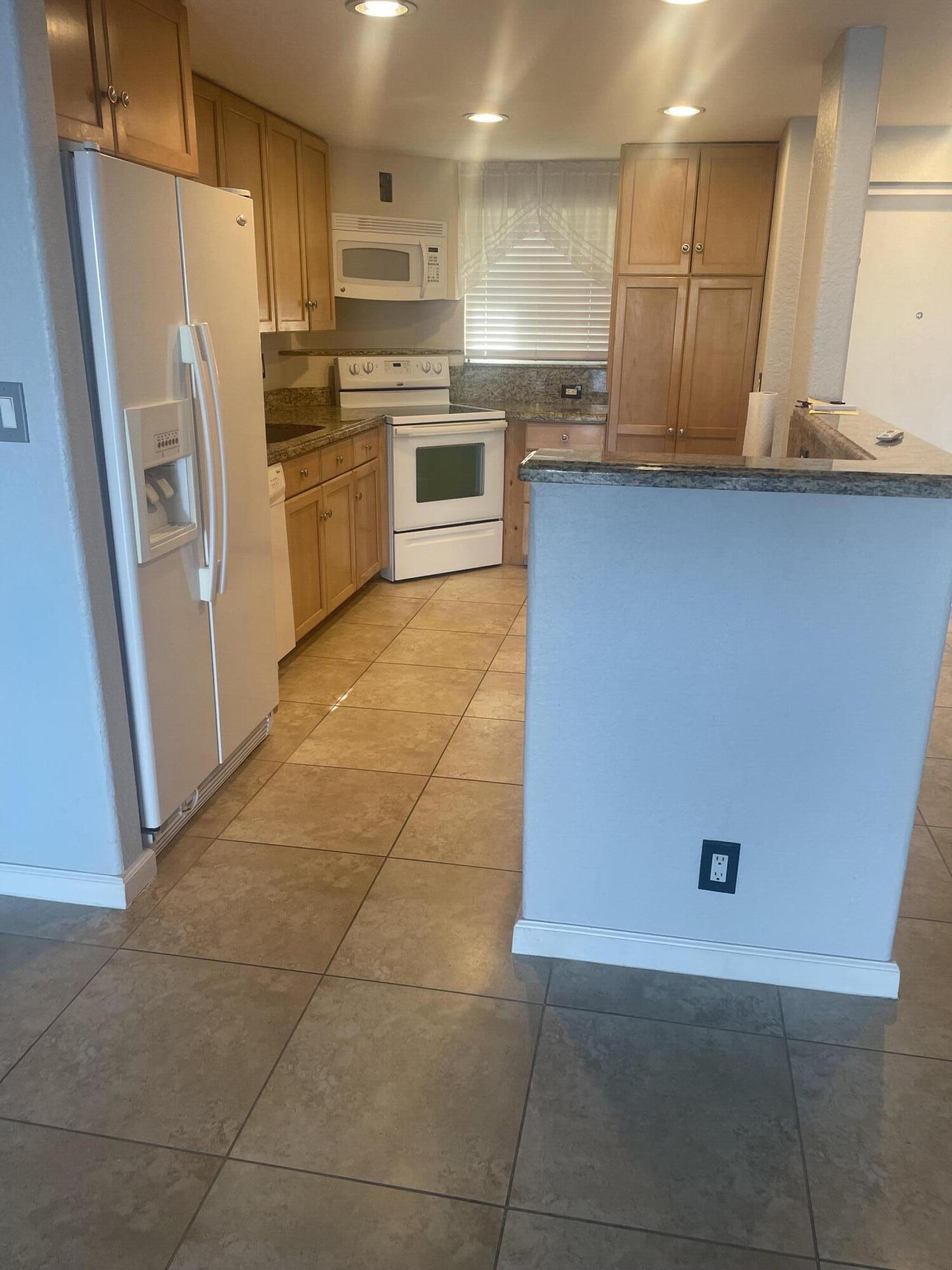 710 Northeast 7th Street, Unit 103 Boynton Beach, FL 33435 - Photo 4 of 12 a kitchen with stainless steel appliances a refrigerator sink and microwave