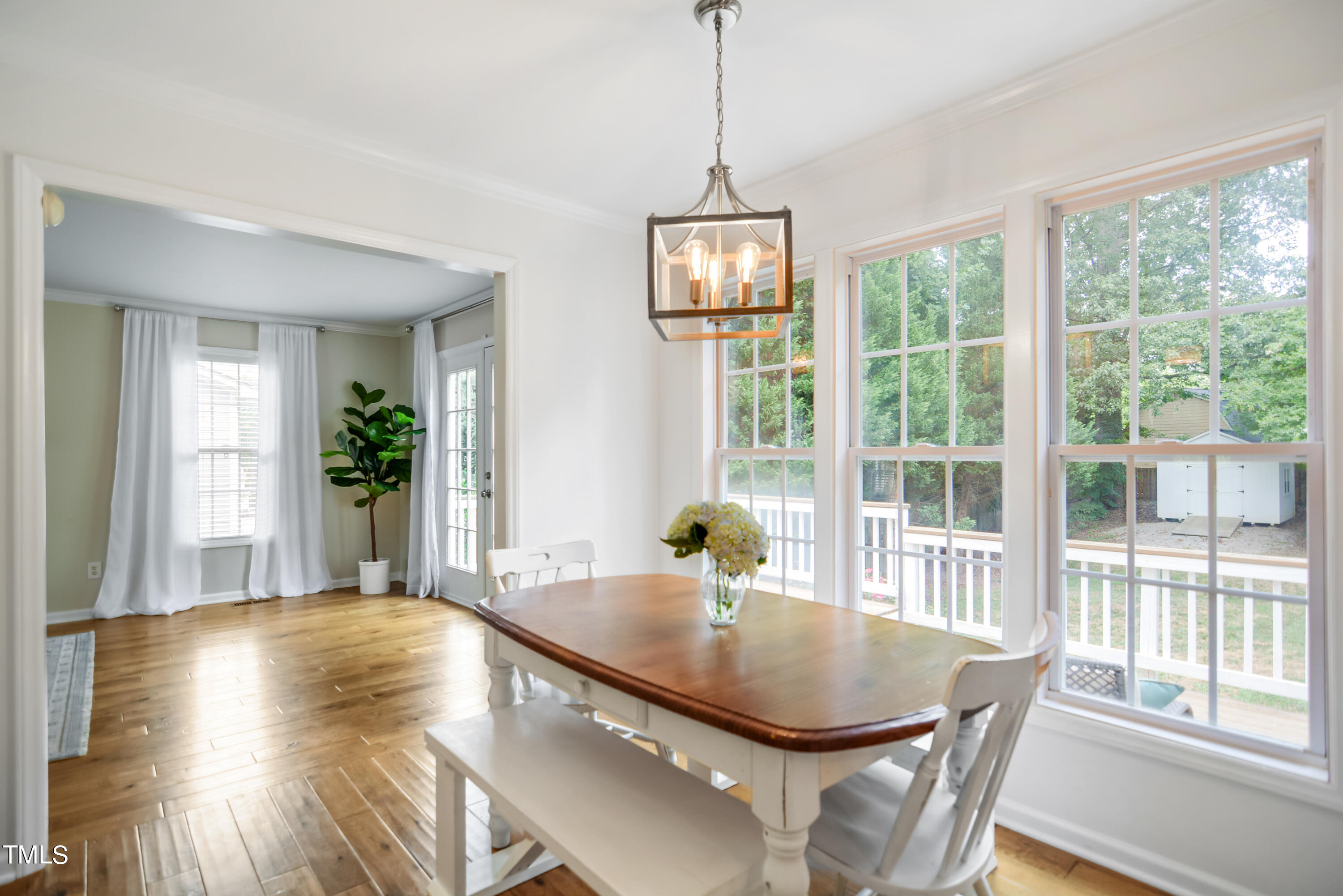 2515 Tryon Pines Drive Raleigh, NC 27603 - Photo 9 of 27 a dining room with wooden floor a chandelier a glass table and chairs