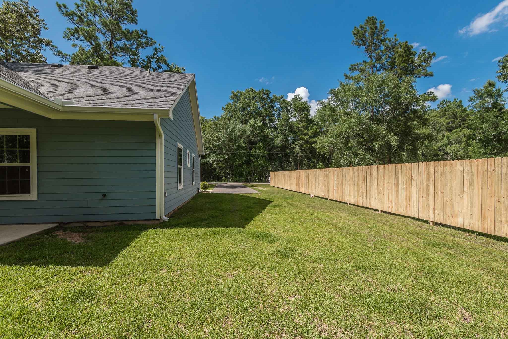 7705 Pin Oak Street Montgomery, TX 77316 - Photo 14 of 15 Left side of house w/ new fence, facing driveway and street