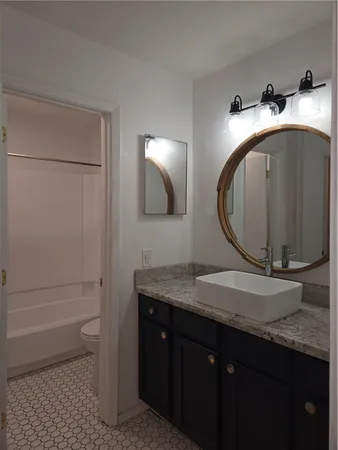 a bathroom with a toilet a sink and vanity