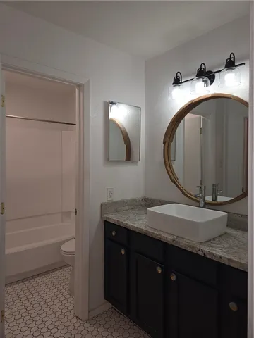 a bathroom with a toilet a sink and vanity