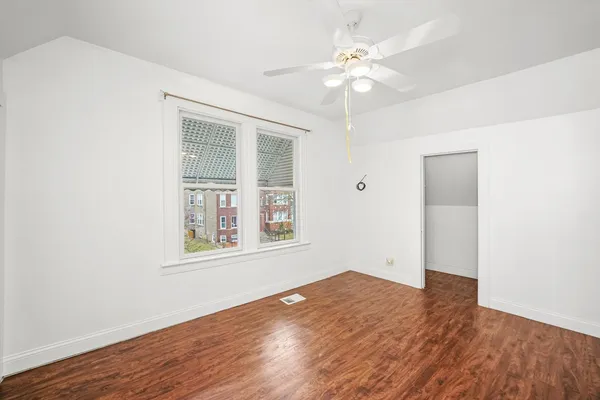 a view of an empty room with wooden floor