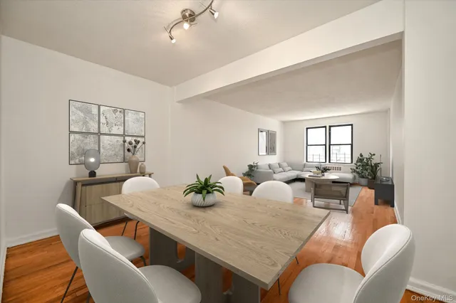 a view of a dining room and livingroom with furniture a large window and wooden floor