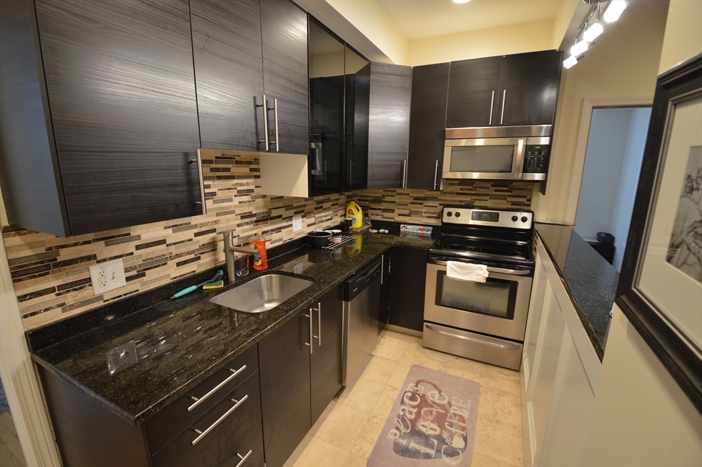 1801 Beacon Street, Unit 4 Brookline, MA 02445 - Photo 7 of 9 a kitchen with stainless steel appliances granite countertop a stove and a sink