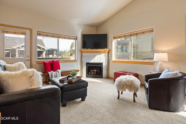 a living room with furniture a flat screen tv and a fireplace