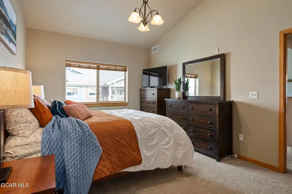 a bedroom with a bed and dresser with mirror
