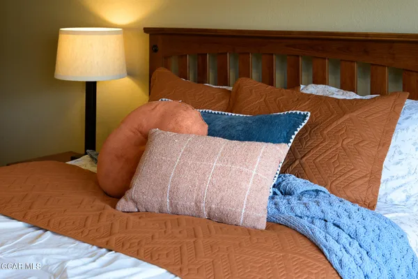 a bed sitting in a bedroom next to a lamp