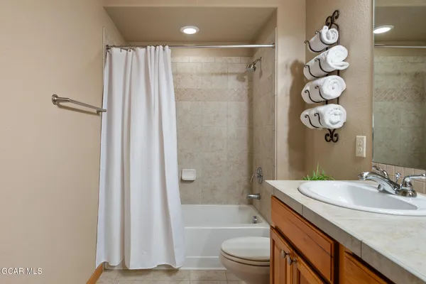 a bathroom with a sink a toilet a tub and shower