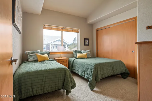 a bedroom with two beds and a large window