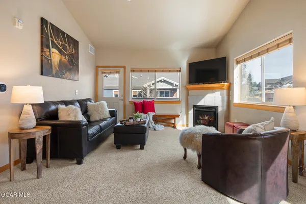 a living room with furniture a fireplace and a flat screen tv