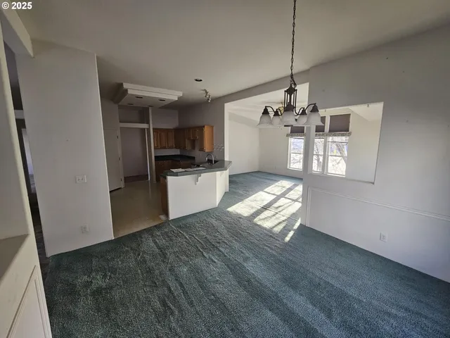 a view of a kitchen with wooden floor and electronic appliances
