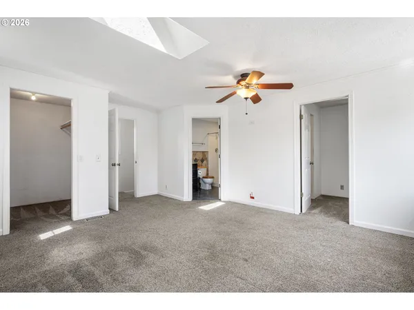 a view of an empty room with a ceiling fan