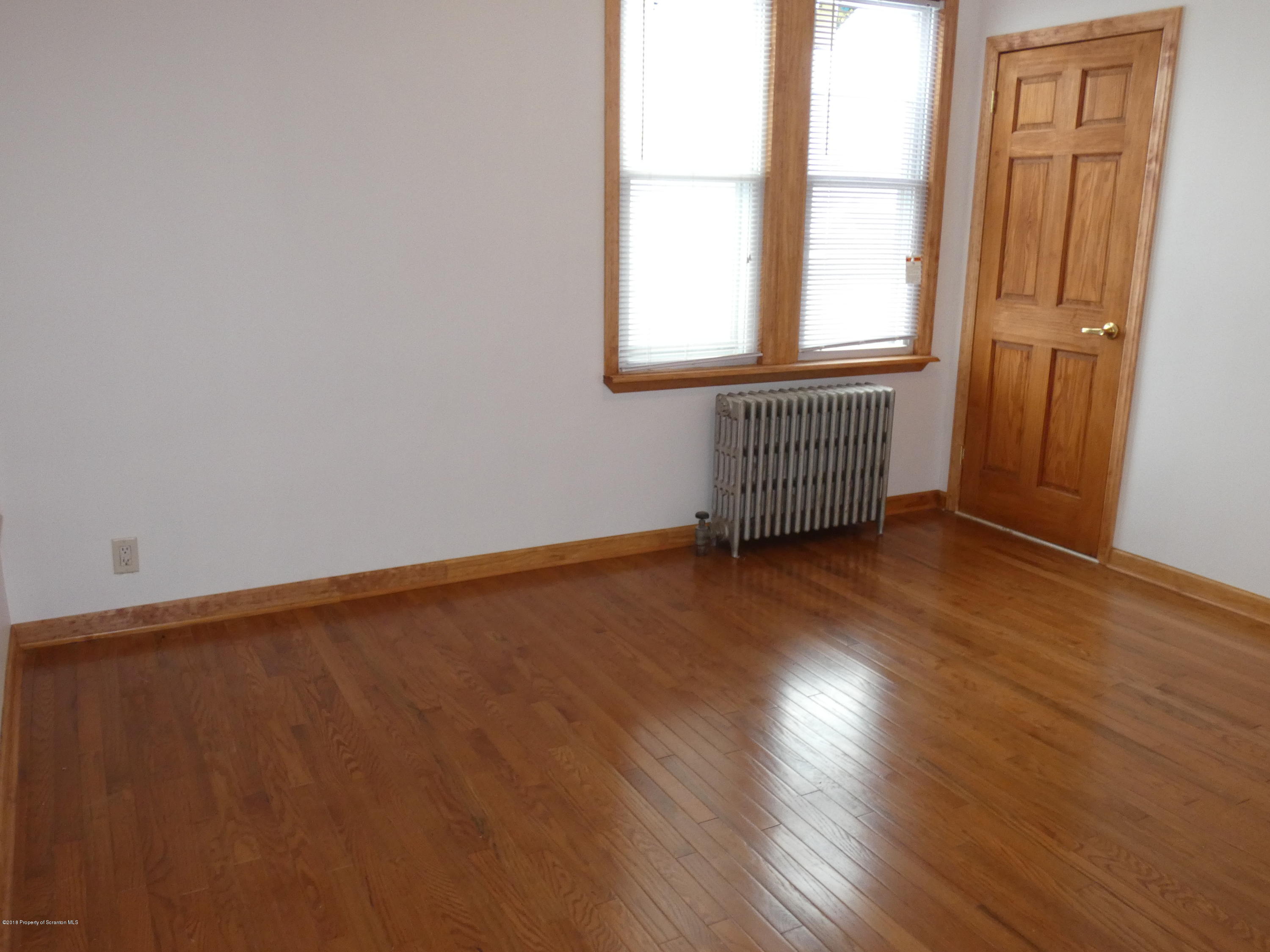 613 Fig Street Scranton, PA 18505 - Photo 11 of 36 an empty room with wooden floor and windows