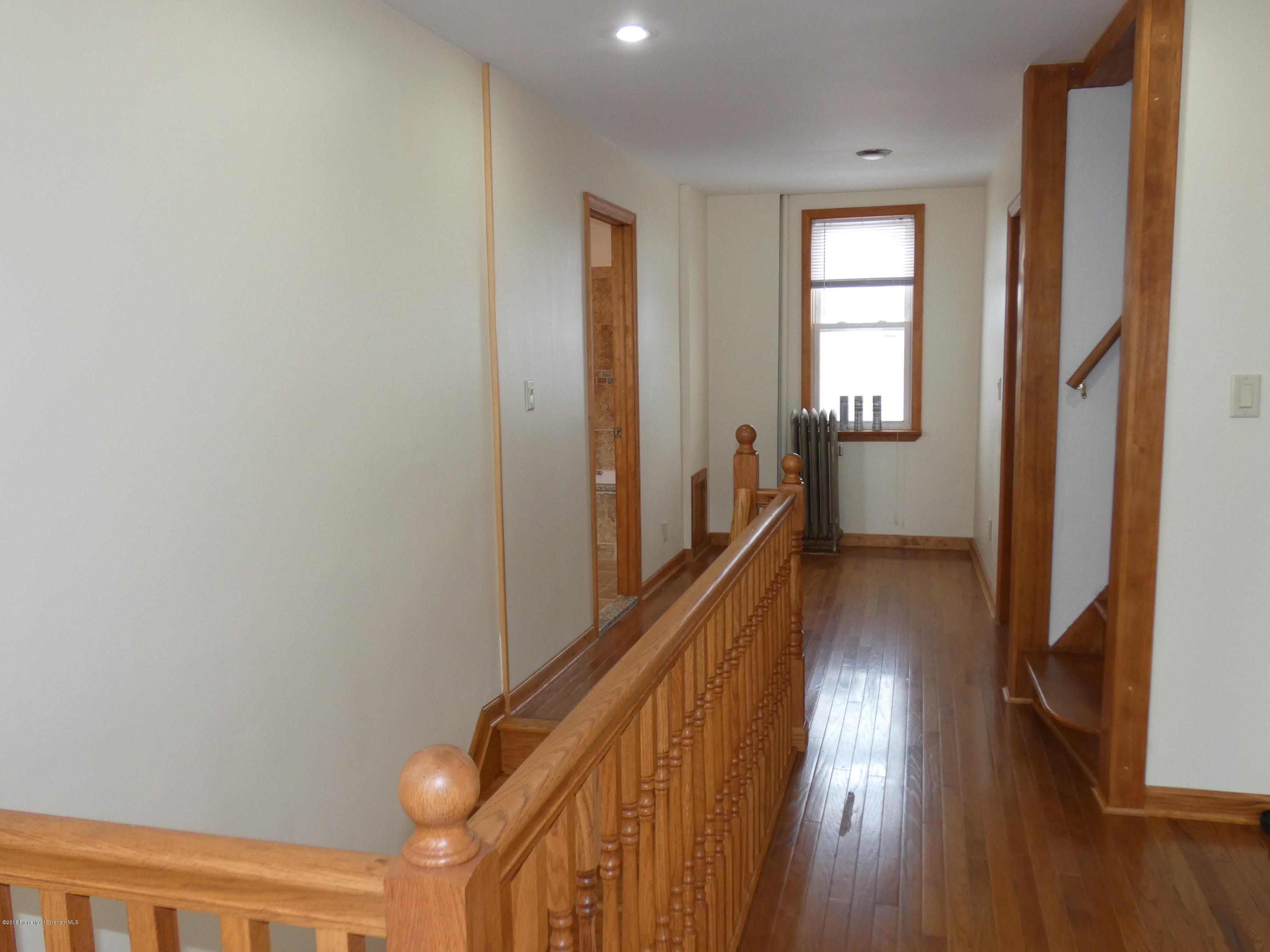 613 Fig Street Scranton, PA 18505 - Photo 22 of 36 a view of a hallway with wooden floor and staircase