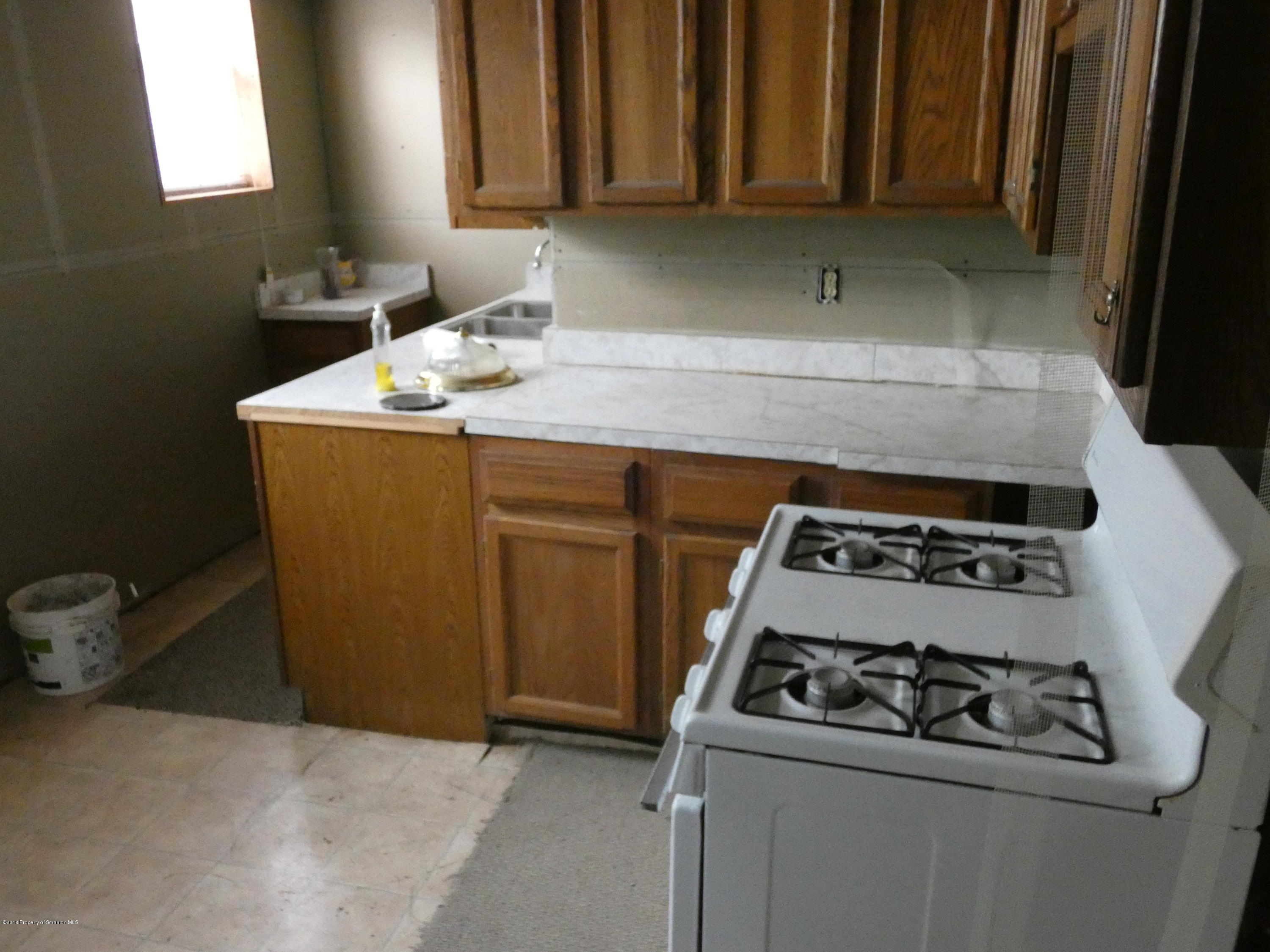 613 Fig Street Scranton, PA 18505 - Photo 30 of 36 a kitchen with granite countertop a sink stove and cabinets