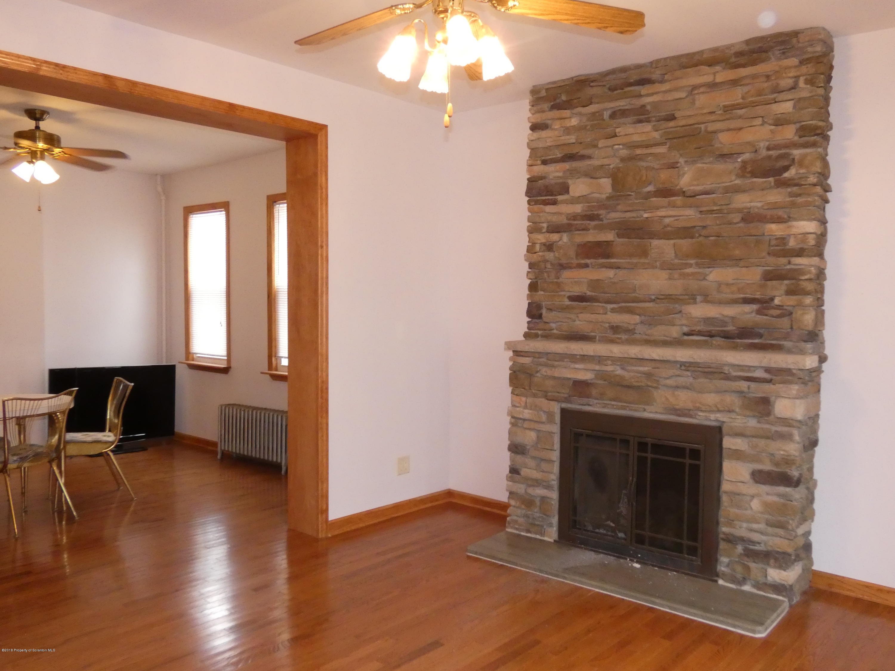 613 Fig Street Scranton, PA 18505 - Photo 10 of 36 a view of a livingroom with wooden floor a fireplace and window