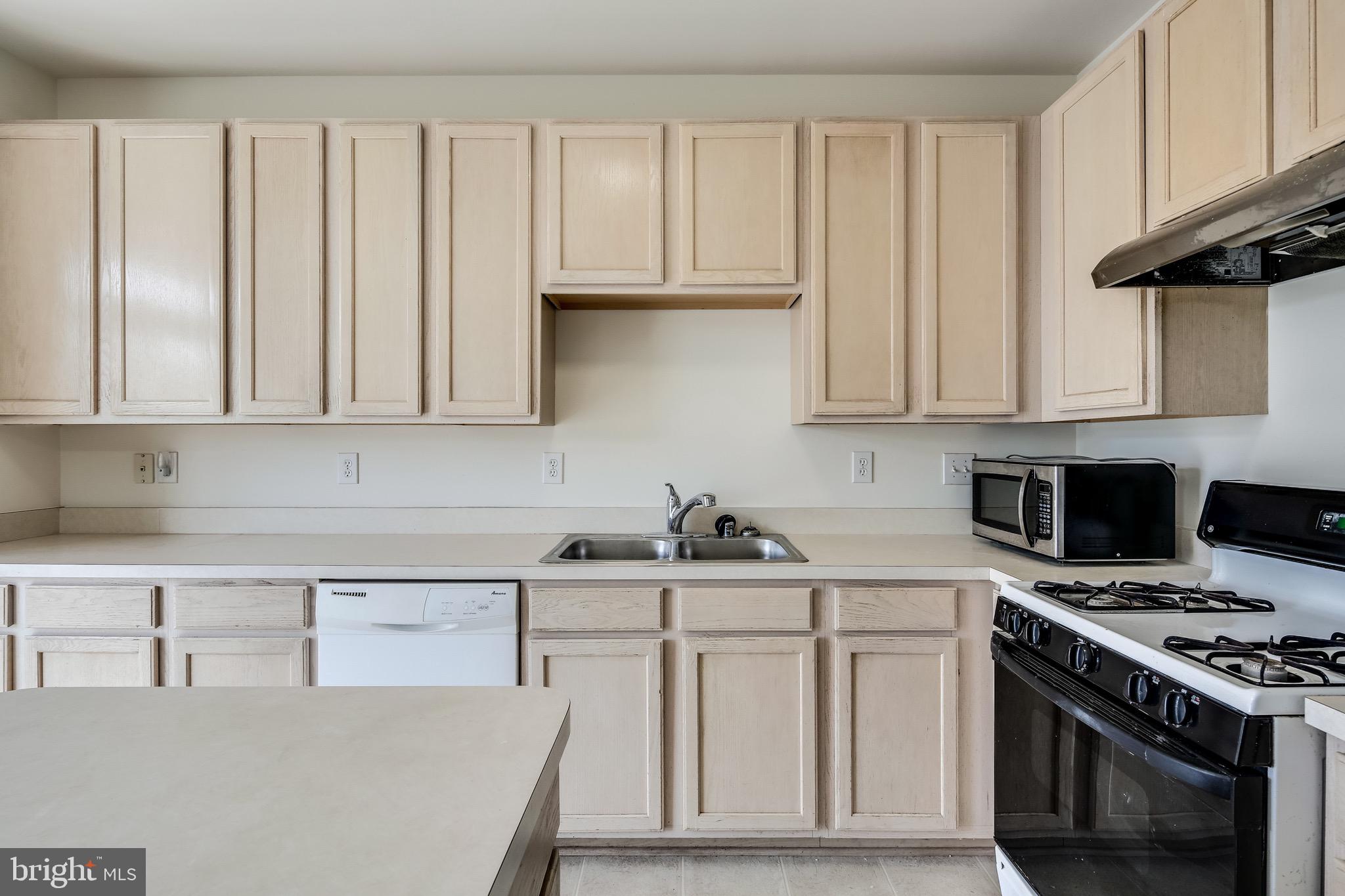 2702 Snowmill Court Ellicott City, MD 21043 - Photo 19 of 34 a kitchen with white cabinets and appliances