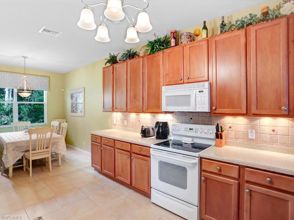 5786 Lago Villaggio Way Naples, FL 34104 - Photo 11 of 29 a kitchen with a sink cabinets and window