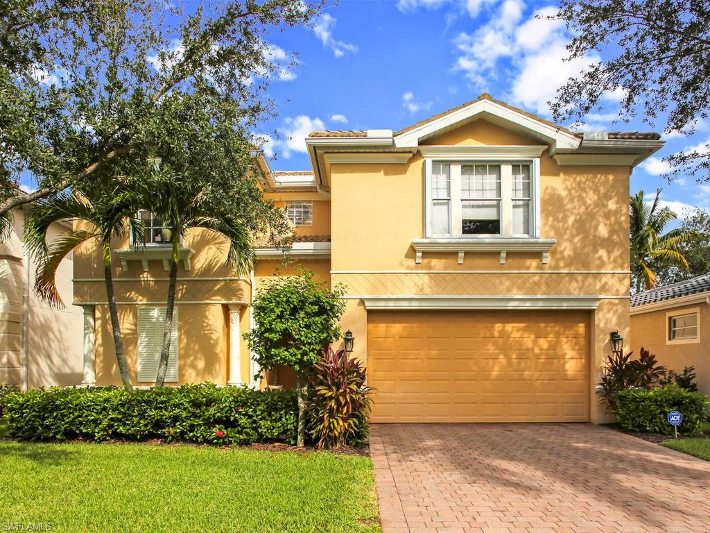 5786 Lago Villaggio Way Naples, FL 34104 - Photo 3 of 29 a front view of a house with a yard and garage