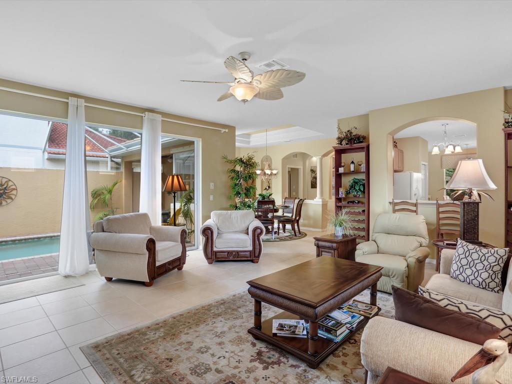 5786 Lago Villaggio Way Naples, FL 34104 - Photo 5 of 29 a living room with furniture a table and a large window